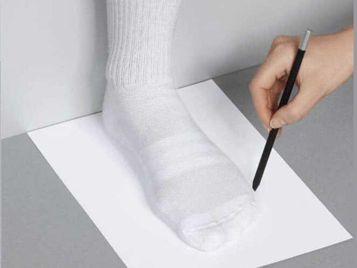 Đặt một tờ giấy trắng xuống sàn, đặt gót chân chạm vào tường