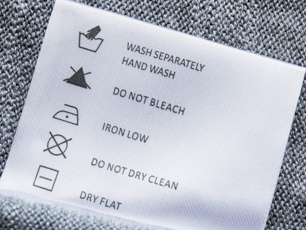 Cận cảnh nhãn mác của một chiếc áo len có ký hiệu Hand wash (Chỉ giặt tay)