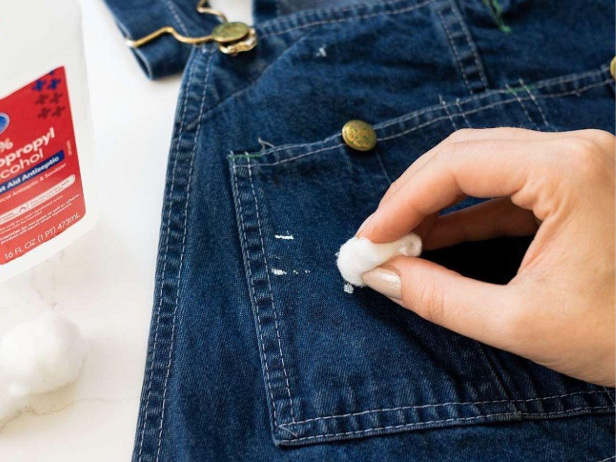 Thấm cồn vào bông gòn để loại bỏ vết mực bút trên quần jean
