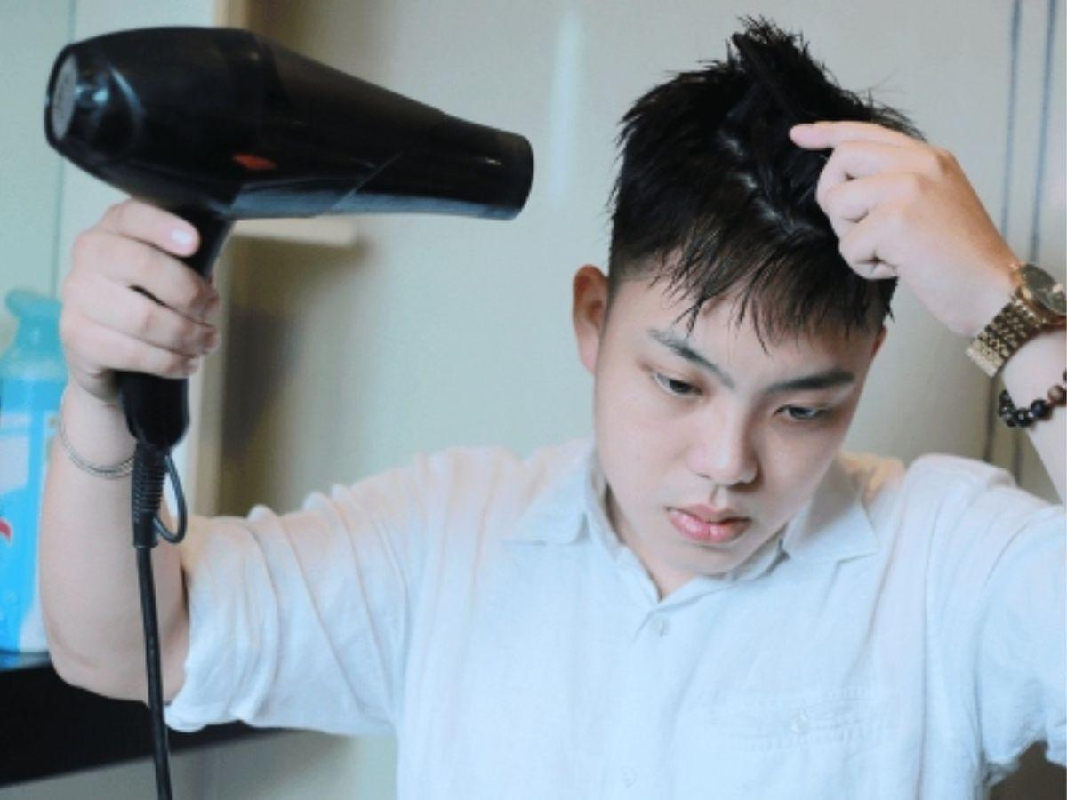 Người nam đang sấy tóc ở nhiệt độ cao