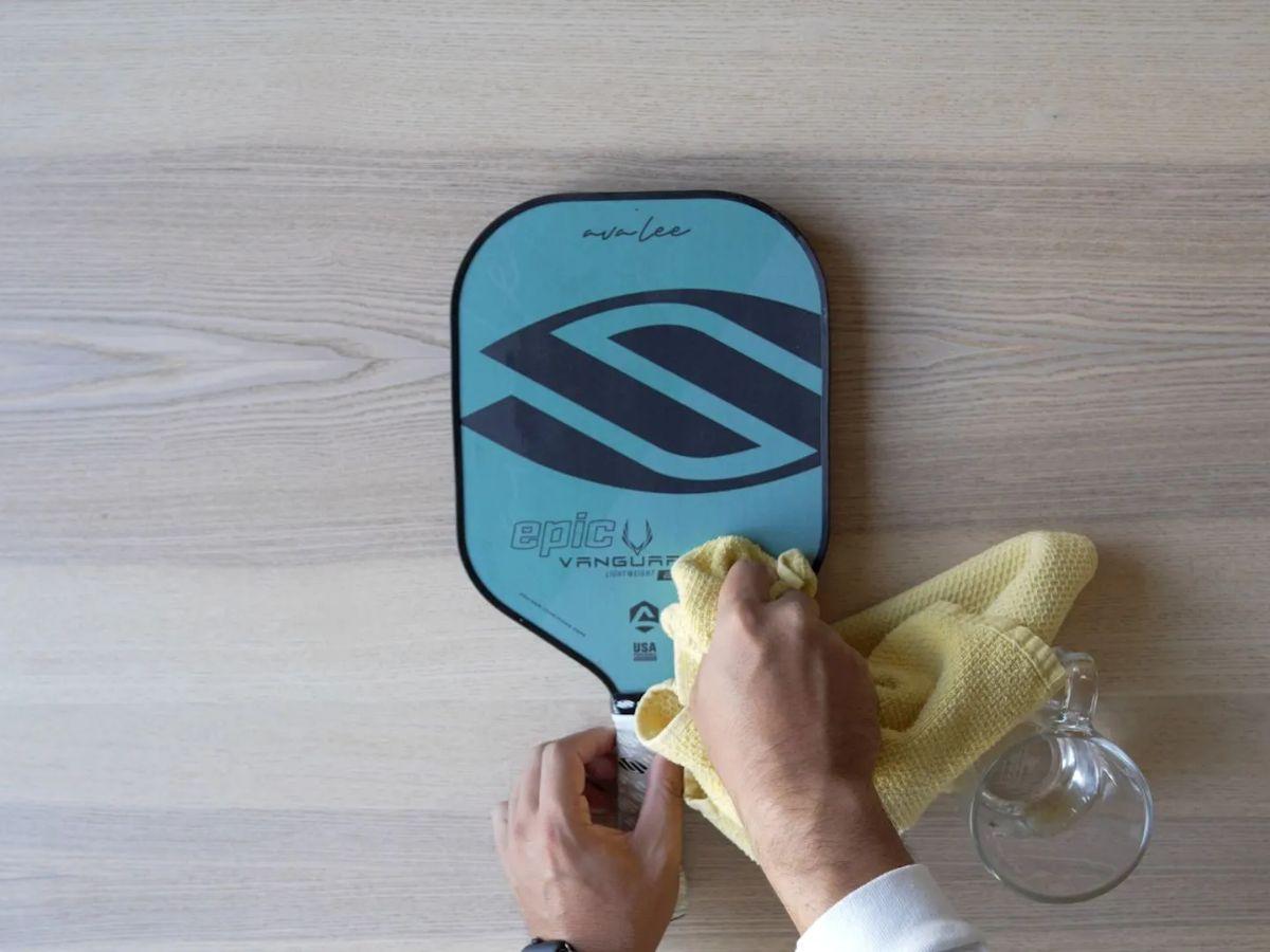 Vệ sinh vợt bằng khăn ẩm mềm để làm sạch bề mặt vợt