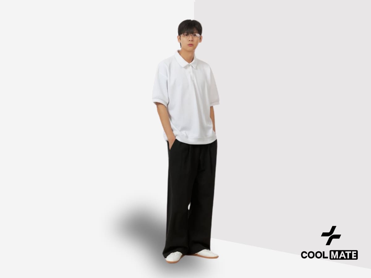 Người mẫu nam mặc áo polo phối cùng quần ống rộng màu đen và sneaker trắng