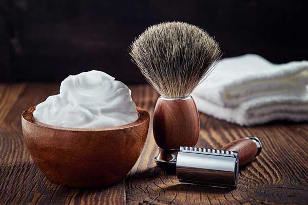 Thợ cắt tóc nam sử dụng chổi quét kem cạo mặt