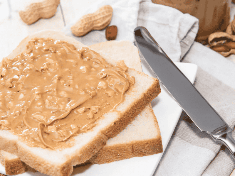 Một lát bánh mì nguyên cám phết bơ đậu phộng giúp cơ thể sẵn sàng luyện tập